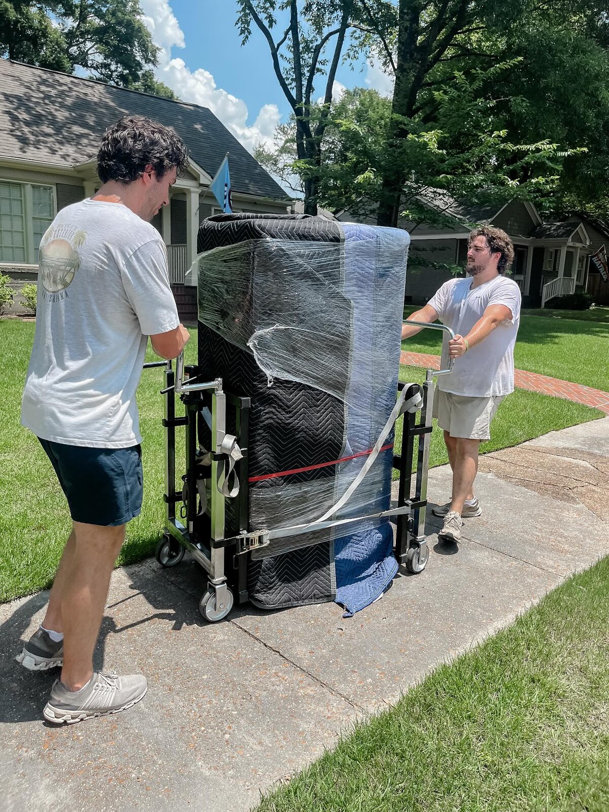 Twins and a Truck crew moving a fully padded and wrapped piano on a piano dolly